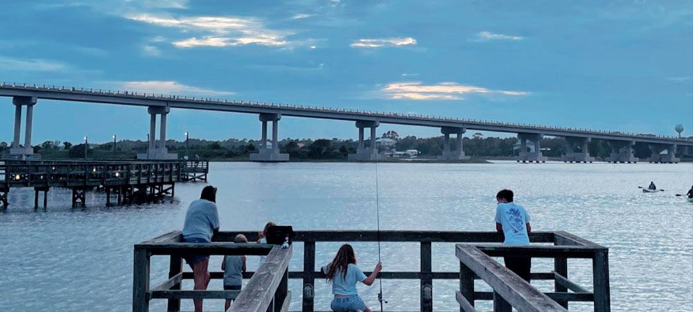 Soundside Park in Surf City, NC has several fishing access platforms like the one shown. Here, the family of the Topsail Guide Editorial Team is taking in the views of the Surf City Bridge while enjoying some light fishing action, perfect for anglers of all ages!